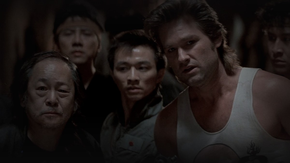 Still from Big Trouble in Little China (1986) — 16:9 still from Letterboxd (og:image, 1200x675 crop), pre-brightened 1.55, baked through scripts/bake_dark_photo.py at factor 0.45, output brightness 24.3